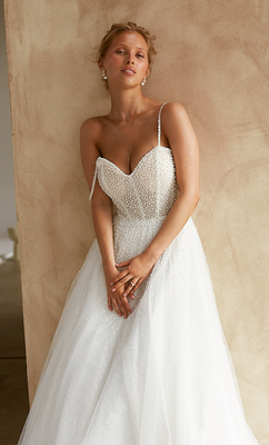 The dazzling bodice features a sweetheart neckline, exposed boning and spaghetti straps