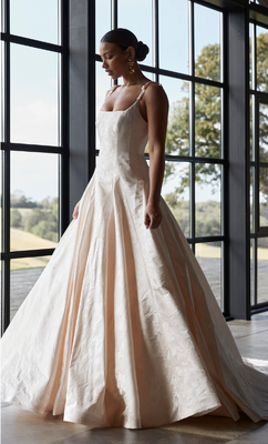 The style is defined by a full skirt with feature sheer godet panels