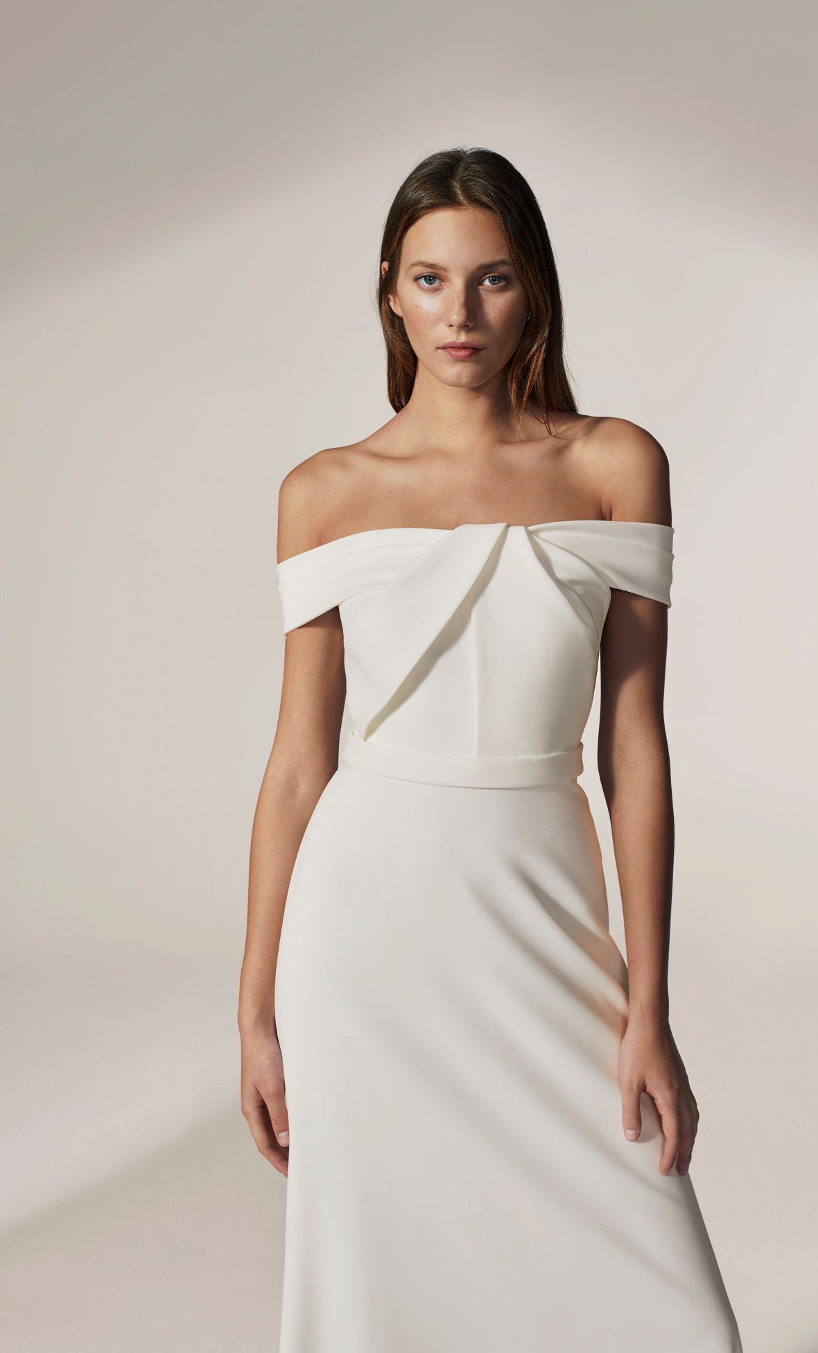 This off-shoulder crepe gown features sculptural pleats: Jesus Peiro 2026